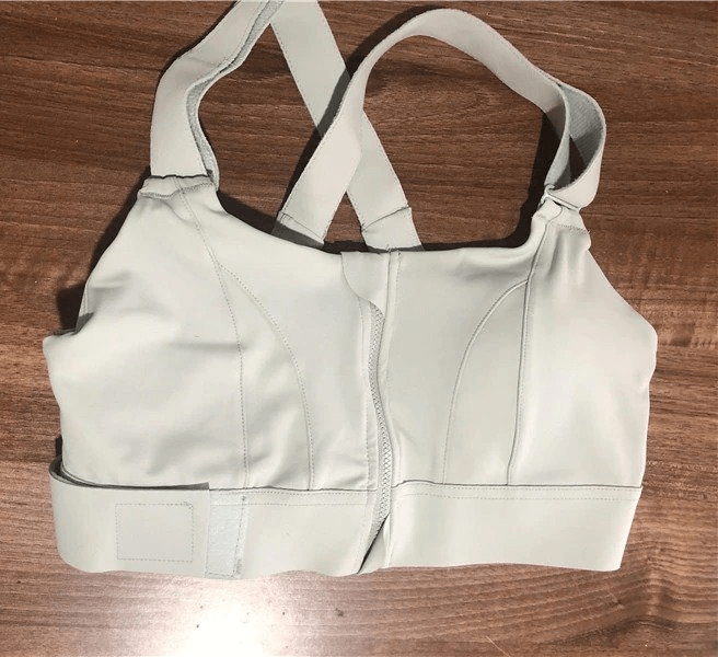 Stylish women's shockproof sports bra with adjustable fastening in light color, perfect for all fitness activities with flexible support.